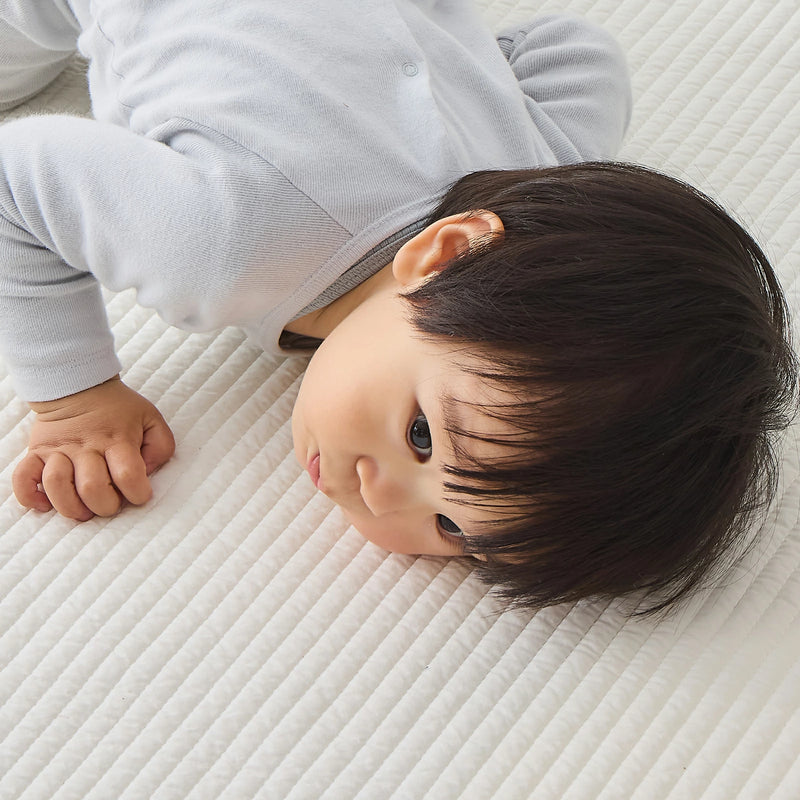 眠る赤ちゃんと敷きふとんの生地