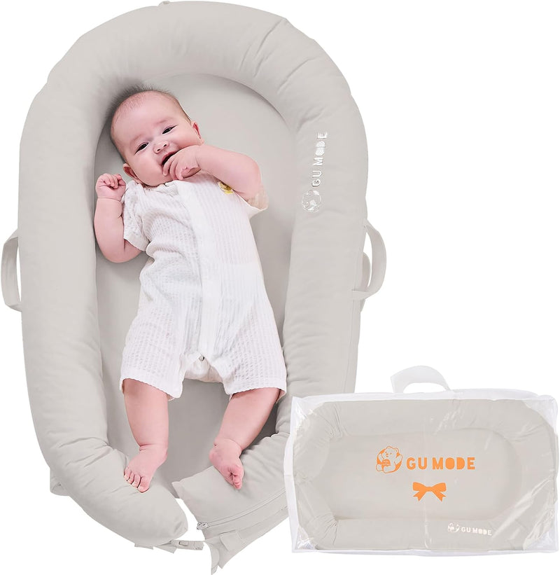 赤ちゃんを寝かせたグレーのベッドインベッドと収納バッグ