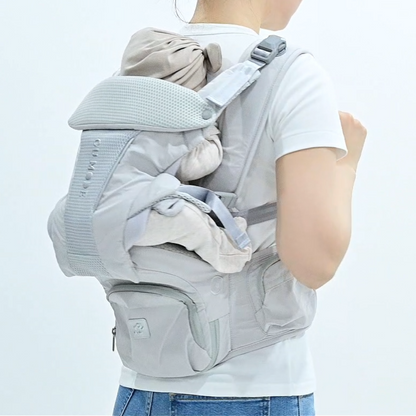 グレーのヒップシート付き抱っこひもを背面から装着した様子